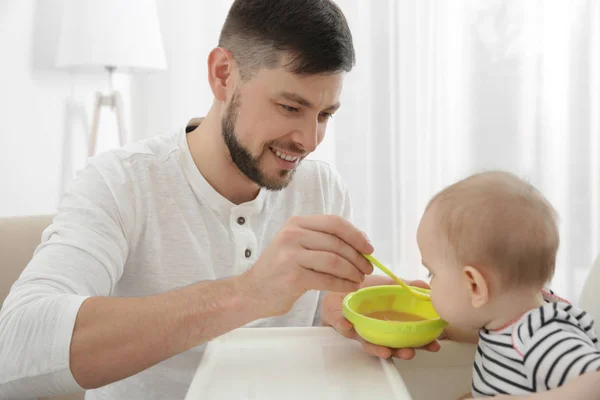 Pai alimentando bonito bebê filha em casa — Fotografia de Stock