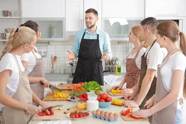 Мужской шеф-повар и группа людей на кулинарных курсах — стоковое фото