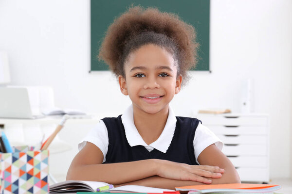 Портрет милой афроамериканской девочки в классе
