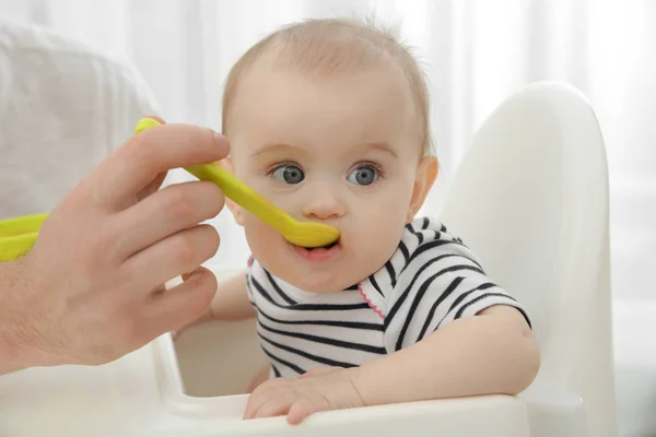 Padre alimentación lindo bebé hija en casa — Foto de Stock