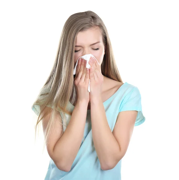 Jovem mulher soprando nariz no tecido contra fundo branco — Fotografia de Stock