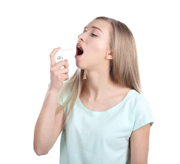 Sick young woman using throat spray on white background — Stock Photo, Image