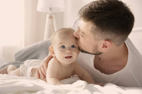 Padre acostado con linda hija bebé en la cama en casa — Foto de Stock