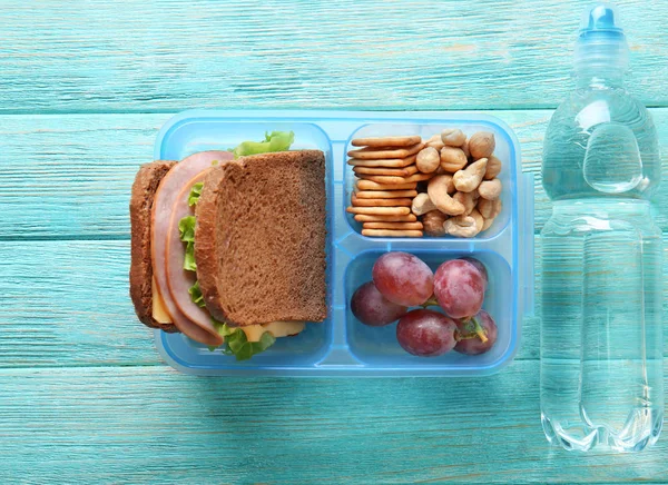 Lunchbox és üveg víz a fából készült háttér — Stock Fotó