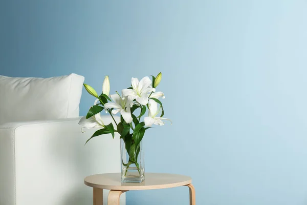 Beautiful white lilies in vase on stool — Stock Photo, Image