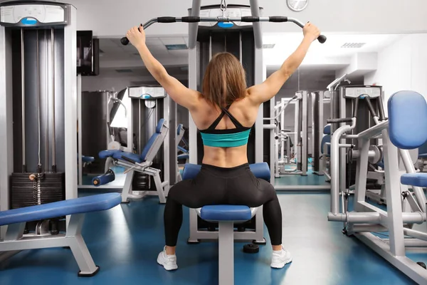 Junge Frau trainiert in einem Fitnessstudio — Stockfoto