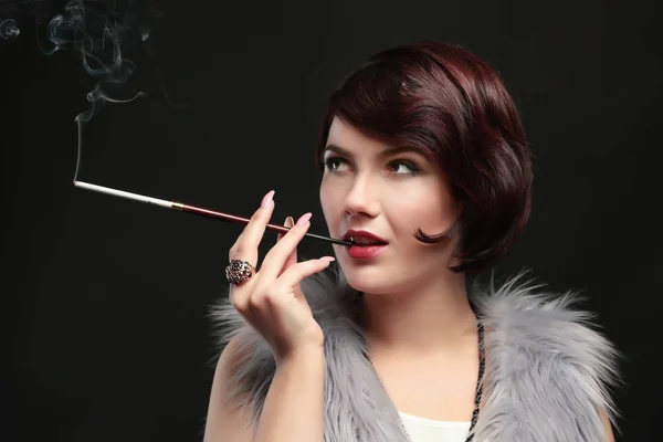 Женщина курит с держателем для сигарет — стоковое фото