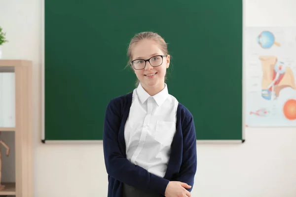 Roztomilá dívka stojící vedle zelené školní tabule v učebně — Stock fotografie