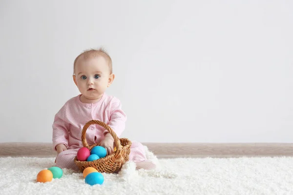 Baby with basket full of Easter eggs — Stock Photo, Image