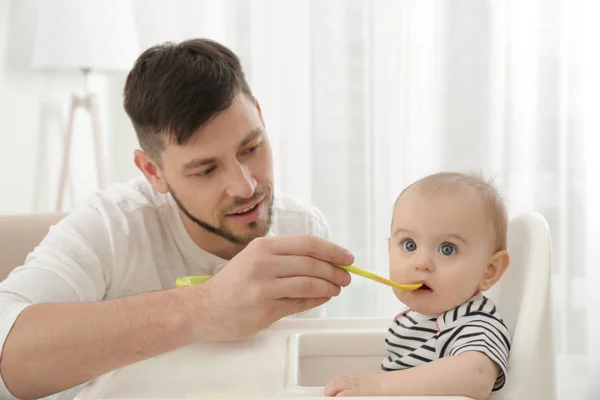 Padre alimentación lindo bebé hija en casa — Foto de Stock