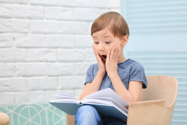 Mignon petit garçon lecture livre à la maison — Photo