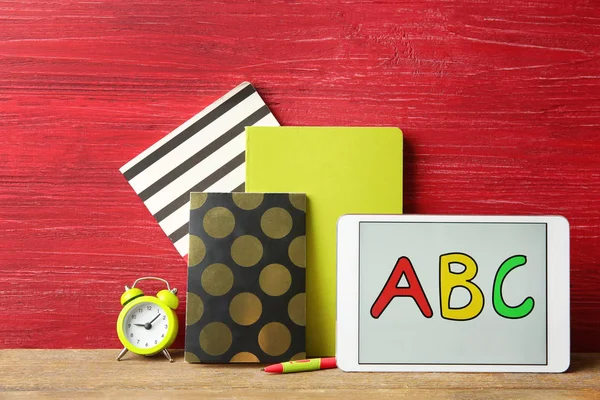 Tableta con mensaje ABC y papelería sobre mesa de madera —  Fotos de Stock