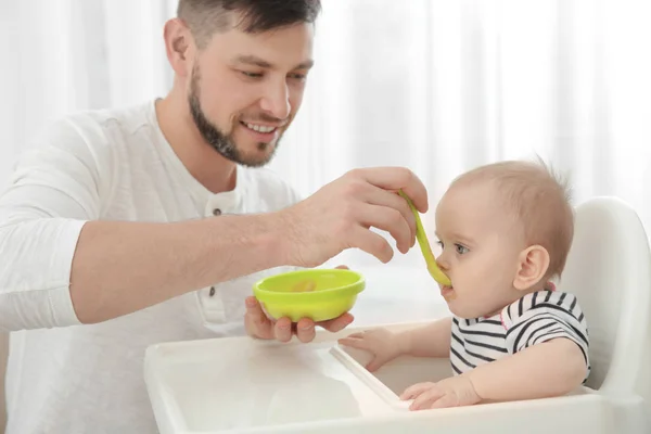 Padre alimentación lindo bebé hija en casa — Foto de Stock