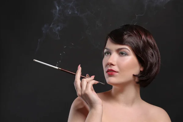 Frau raucht mit Zigarettenhalter lizenzfreie Stockfotos