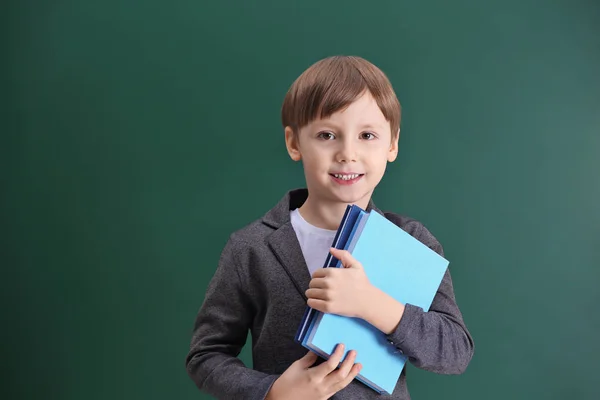 Cute little boy on school blackboard background Stock Picture