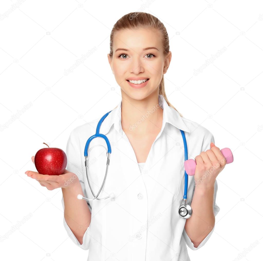 Diet concept. Female nutritionist with apple and dumbbell on white background
