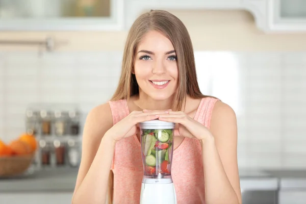 Mooie jongedame fruit smoothie maken in de keuken — Stockfoto