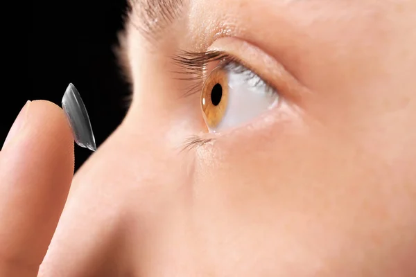 Mujer poniendo lente de contacto en el ojo — Foto de Stock
