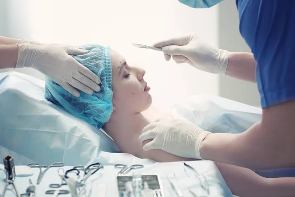 Plastic surgeon operating patient in clinic