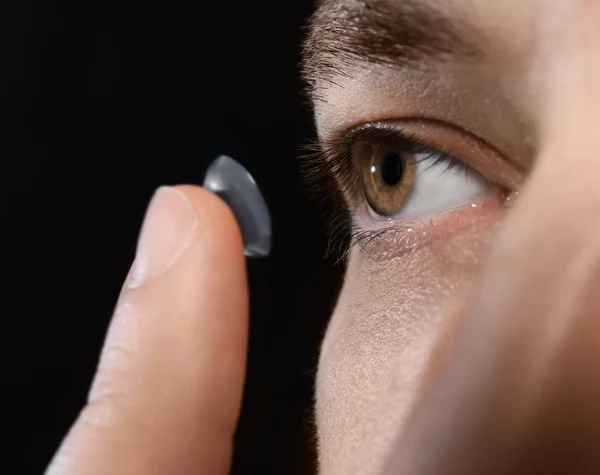 Mann setzt Kontaktlinse ein — Stockfoto