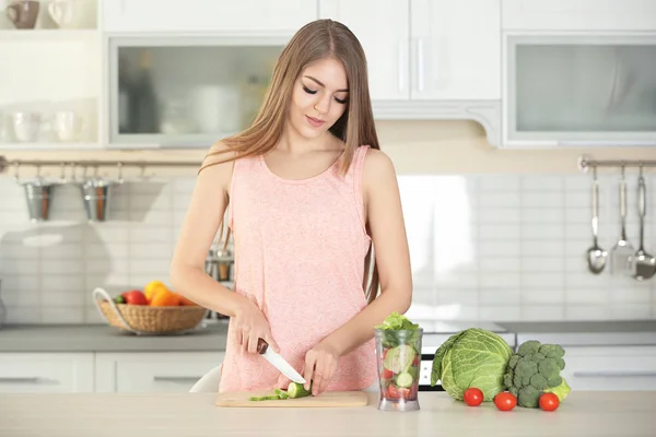 Ung vacker kvinna att göra grönsak smoothie i köket — Stockfoto