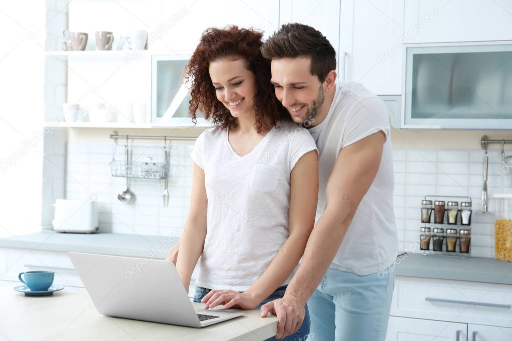 ouple with laptop in kitchen
