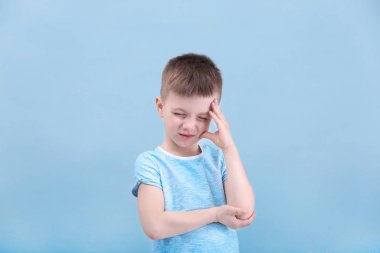 Küçük çocuk renk arka plan üzerinde baş ağrısı muzdarip