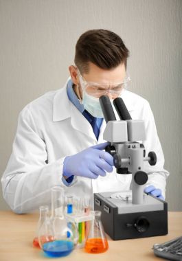 Doktor mikroskopla çalışıyor.  