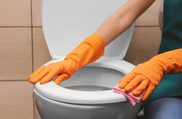 Woman cleaning toilet with rag — Stock Photo, Image