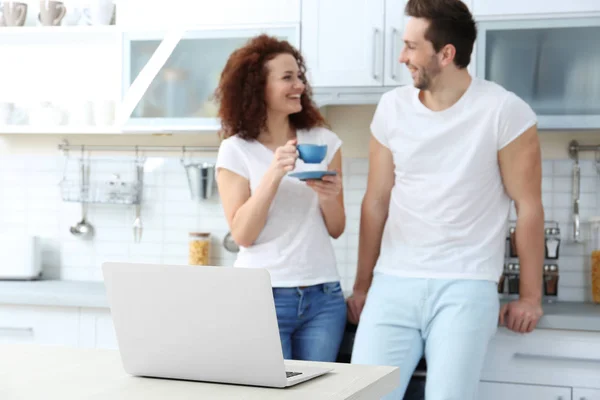 Couple avec ordinateur portable dans la cuisine — Photo