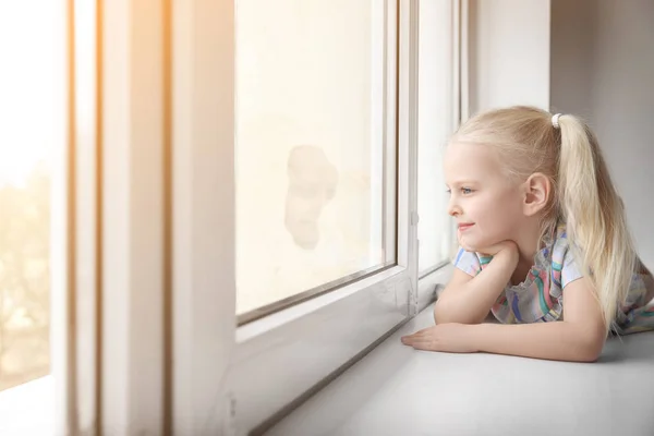 可爱的小女孩趴在窗台上 — 图库照片