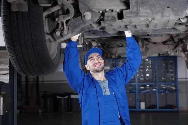 Young mechanic fixing wheel — Stock Photo, Image