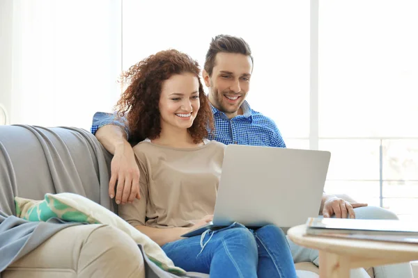 Feliz pareja joven con ordenador portátil — Foto de Stock