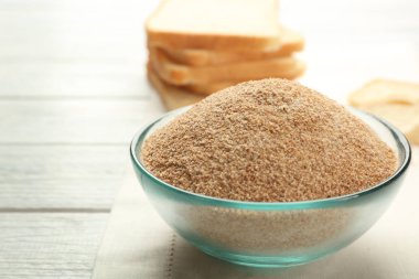 Ahşap arka plan üzerinde ekmek kırıntısı küçük kase