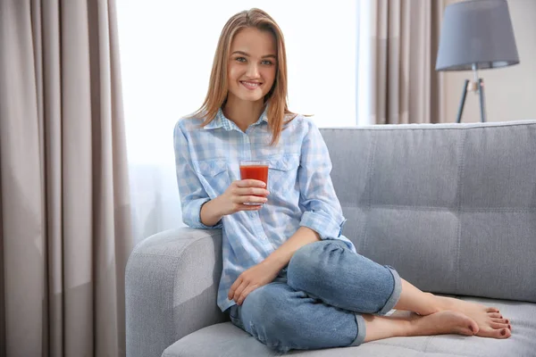 Mujer con jugo fresco sentado en el sofá — Foto de Stock
