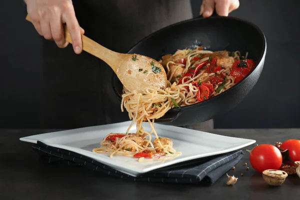 Mujer poniendo espaguetis de pollo — Foto de Stock