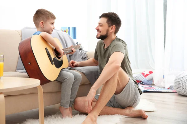 Padre enseñando hijo a tocar la guitarra — Foto de Stock