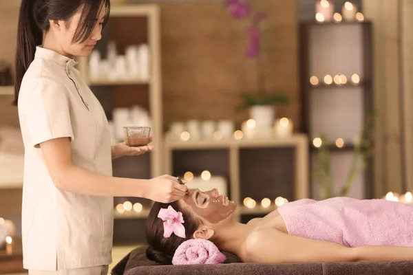 Mujer joven que tiene tratamiento facial en el salón de spa —  Fotos de Stock