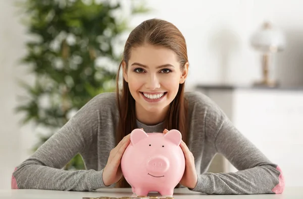 Jonge vrouw met spaarvarken bank — Stockfoto