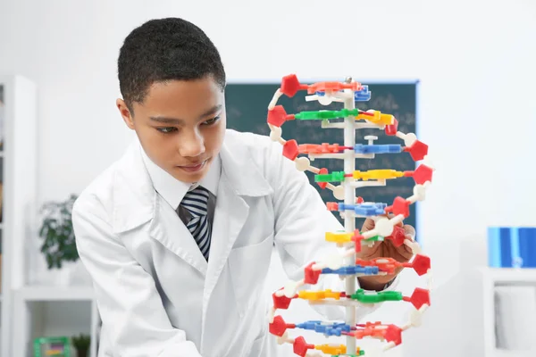 Шкільний хлопчик вивчає модель ДНК — стокове фото