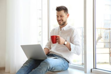 dizüstü bilgisayar ile yakışıklı genç  