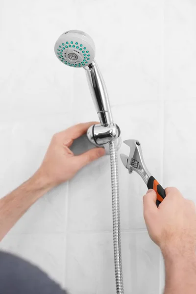 Plumber repairing shower head in bathroom — Stock Photo, Image