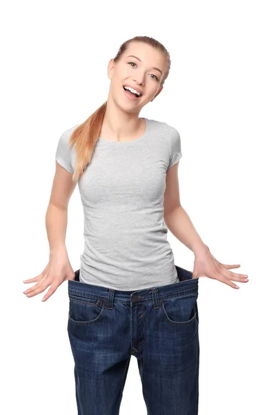 Conceito de dieta. Jovem mulher bonita em jeans grandes no fundo branco — Fotografia de Stock