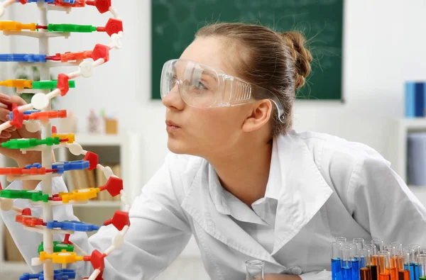 Beautiful school girl studying DNA model in chemistry class — Stock Photo, Image