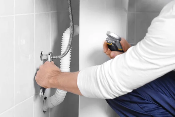 Male hands fixing flexible hose in bathroom, closeup — Stock Photo, Image