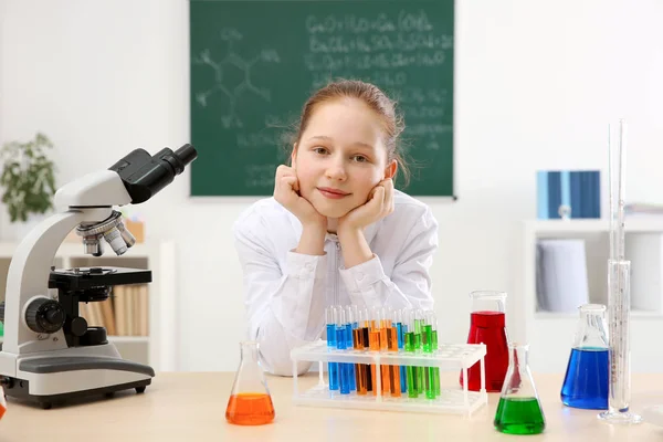 Szkoła piękna dziewczyna siedzi przy stole w klasie chemii — Zdjęcie stockowe