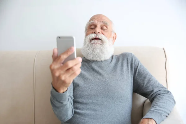 Старший мужчина делает селфи со смартфоном — стоковое фото