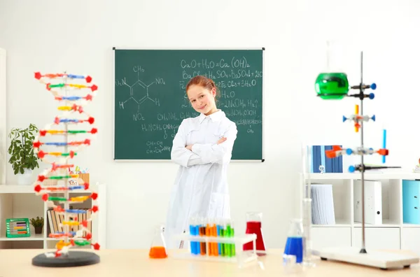 School girl standing at blackboard in chemistry class — Stock Photo, Image