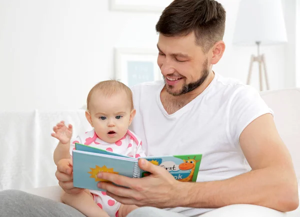 Отец показывает книгу милому ребенку — стоковое фото
