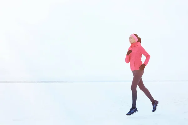 Молодая красивая женщина бегает в зимний день — стоковое фото